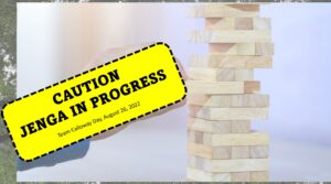 A Jenga tower with text that says “Caution Jenga in Progress”